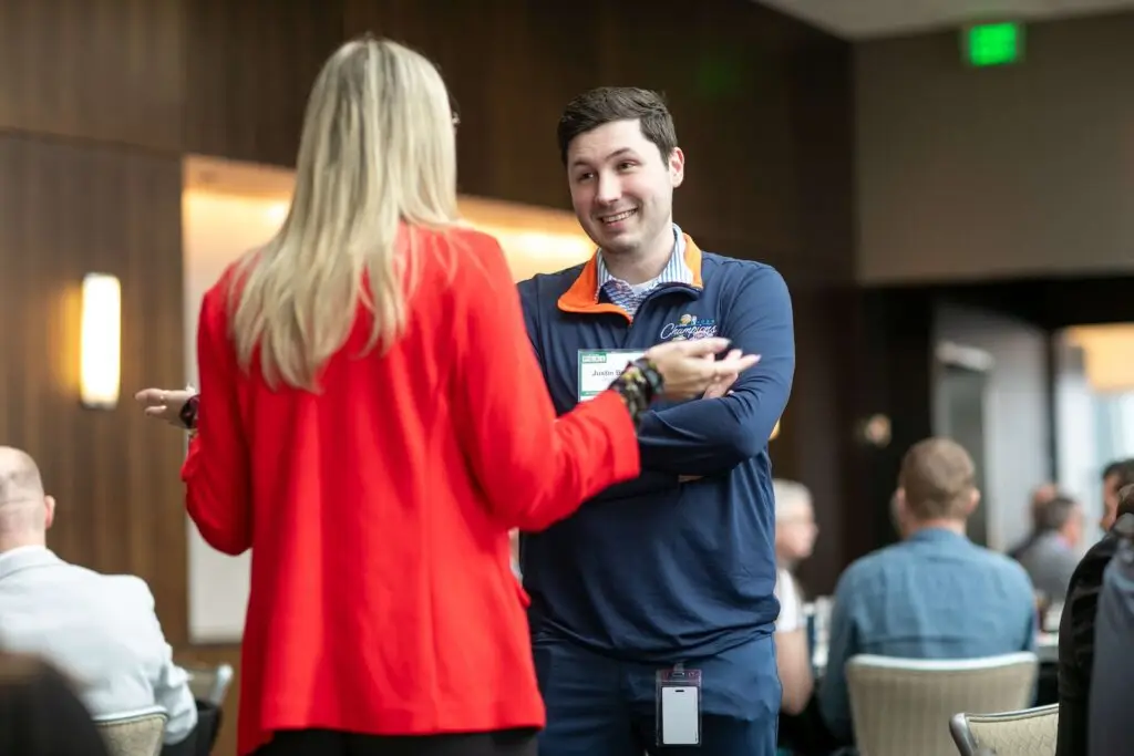Two conference attendees talking and smiling during a networking session at a professional event.