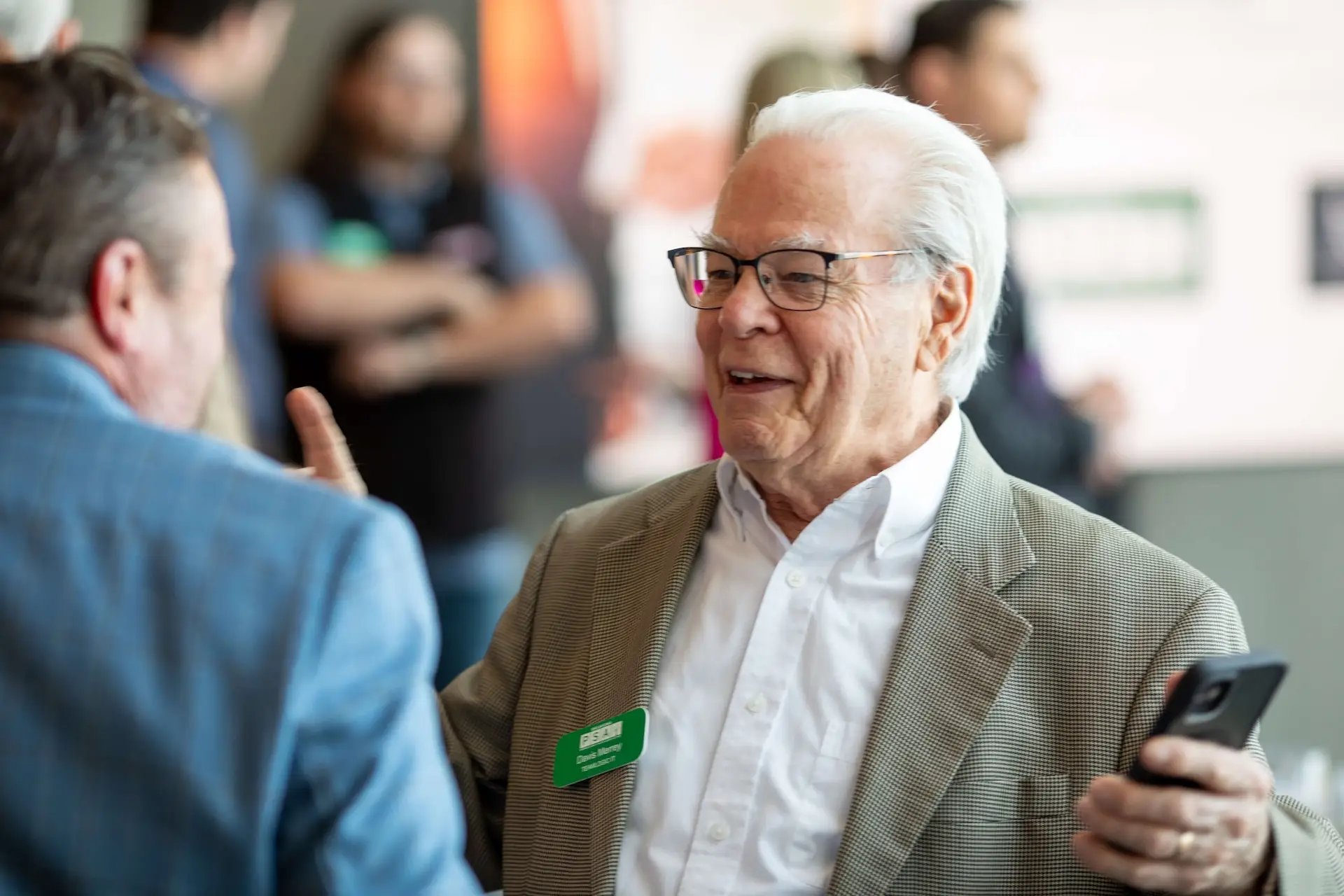 Two conference attendees talking and smiling during a networking session at a professional event.